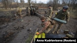 Ukrainian soldiers prepare cannon shells before firing them toward Russian positions in Donetsk region on January 1.