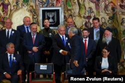 یائیر لاپید و نتانیاهو در حضور برخی از نمایندگان دور جدید پارلمان اسرائیل دست می‌دهند.