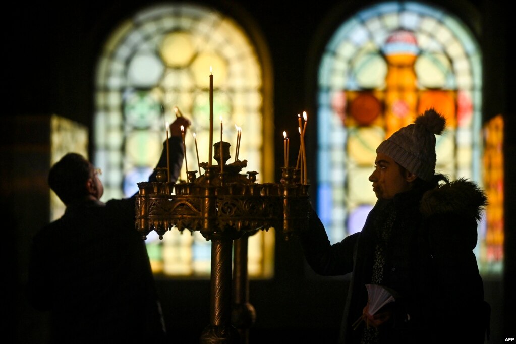 Besimtarët e krishterë ortodoksë ndezin qirinj gjatë meshës së Krishtlindjes në Katedralen Alexander Nevski në Sofje të Bullgarisë. 25 dhjetor 2022.