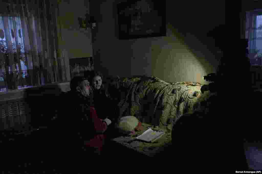 A flashlight illuminates a room as a paramedic treats a young girl following the Russian shelling on November 22.