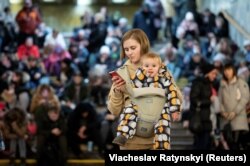 Oameni adăpostiți într-o stație de metrou din Kiev în timpul atacului cu rachete de joi dimineață.