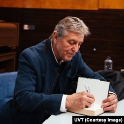 Andrei Șerban oferă autografe pe cartea sa Niciodată singur.