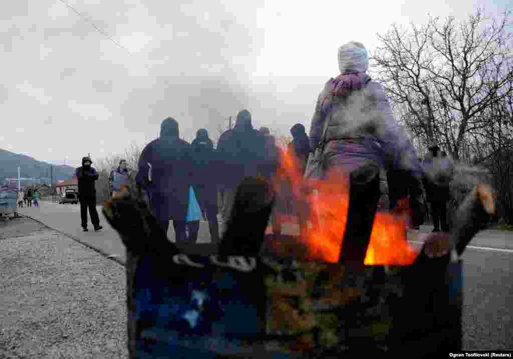 Kosovar Serbs warm themselves near the village of Rudine on December 13. Kosovar Prime Minister Albin Kurti said on December 13 that Pristina will apply to join the European Union this week, a process that is expected to take years, if not decades, and is dependent on normalizing relations with Serbia.