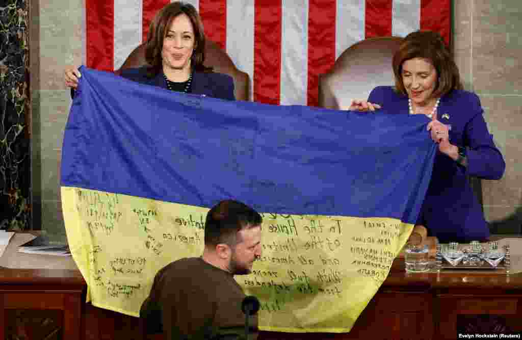 Harris (majtas) dhe kryetarja e Dhomës së Përfaqësuesve të Kongresit amerikan, Nancy Pelosi, duke mbajtur një flamur ukrainas me nënshkrime, të cilin e kishte sjellë nga Bahmuti presidenti ukrainas, Volodymyr Zelensky, gjatë fjalimit të tij në Kongresin amerikan, më 21 dhjetor 2022.