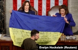 U.S. Vice President Kamala Harris (left) and U.S. House Speaker Nancy Pelosi hold an inscribed Ukrainian flag brought by Ukrainian President Volodymyr Zelenskiy from the frontline city of Bakhmut at a joint session of the U.S. Congress on December 21.
