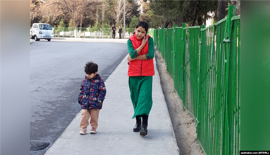 Aşgabat. Jigisi bilen barýarka telefonda gürleşýän gyz.