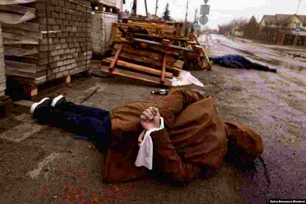 Целы забітых мясцовых жыхароў са зьвязанымі рукамі на вуліцах украінскага гораду Буча падчас расейскага ўварваньня ва Ўкраіну. 3 красавіка 2022&nbsp;