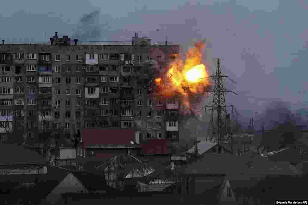 Rusiye tankı Mariupolde mesken evge ateş açqan soñ patlav oldı, 2022 senesi martnıñ 11-i.