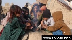 شماری از کودکان خانواده های بیجا شده داخلی در ولایت هرات آتش افروخته اند و خود شان را گرم می‌کنند، عکس از آرشیف