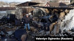 Місцевий житель оглядає залишки свого гаража, зруйнованого під час удару російського безпілотника в селі Старі Безрадичі Київської області, 19 грудня 2022 року