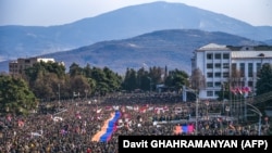 Nagorno-Karabakh - Protesters hold a giant Armenian flag as they attend a rally in Stepanakert on December 25, 2022.
