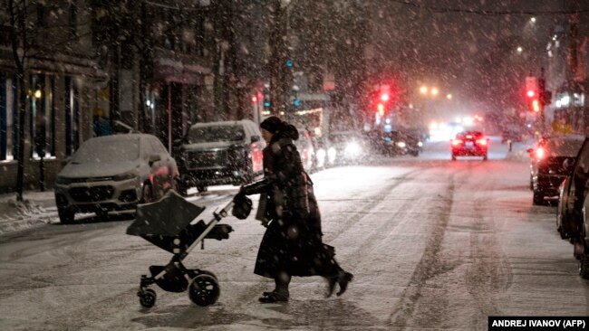 Një grua duke kaluar rrugën në Montreal në Kanadë. 23 dhjetor 2022.