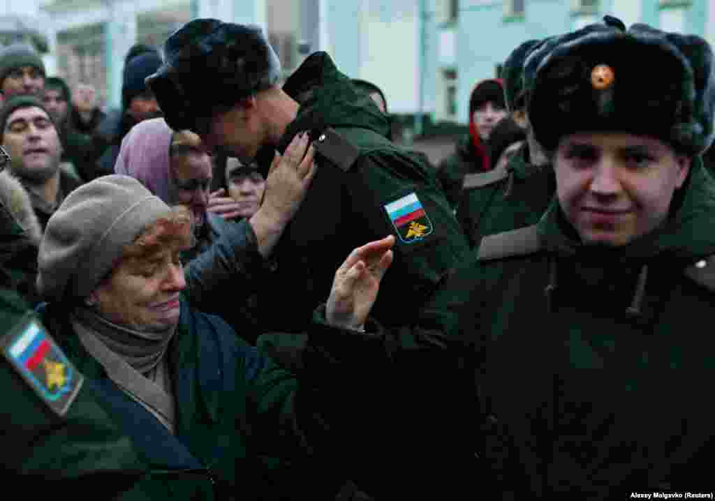 Katonai szolgálatra behívott orosz férfiak búcsúznak hozzátartozóiktól az omszki vasútállomáson 2022. november 10-én