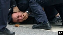 Mai mulți polițiști imobilizează un protestatar în Shanghai, China, pe 27 noiembrie 2022. În ultimele zile au avut loc proteste în cel puțin zece mari orașe față de strategia severă „Zero Covid” a regimului de la Beijing.