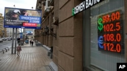 People walk past a currency-exchange office in Moscow in August.