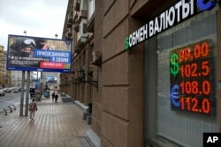 People walk past a currency exchange office in Moscow in August.