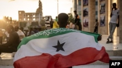 Маж држи знаме на Сомалиленд пред споменикот на војната во Харгеиса, 7 ноември 2024 година.