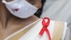 یک داوطلب روبانی به علامت بیماری ایدز در روز جهانی ایدز به لباس خود سنجاق کرده است