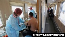 A man receives a dose of the Sputnik V vaccine against COVID-19 on a medical train at a railway station in the town of Tulun in Russia's Irkutsk Region. 