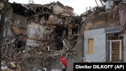 Жінка біля зруйнованого будинку в Слов'янську на Донеччині, жовтень 2022 року 
