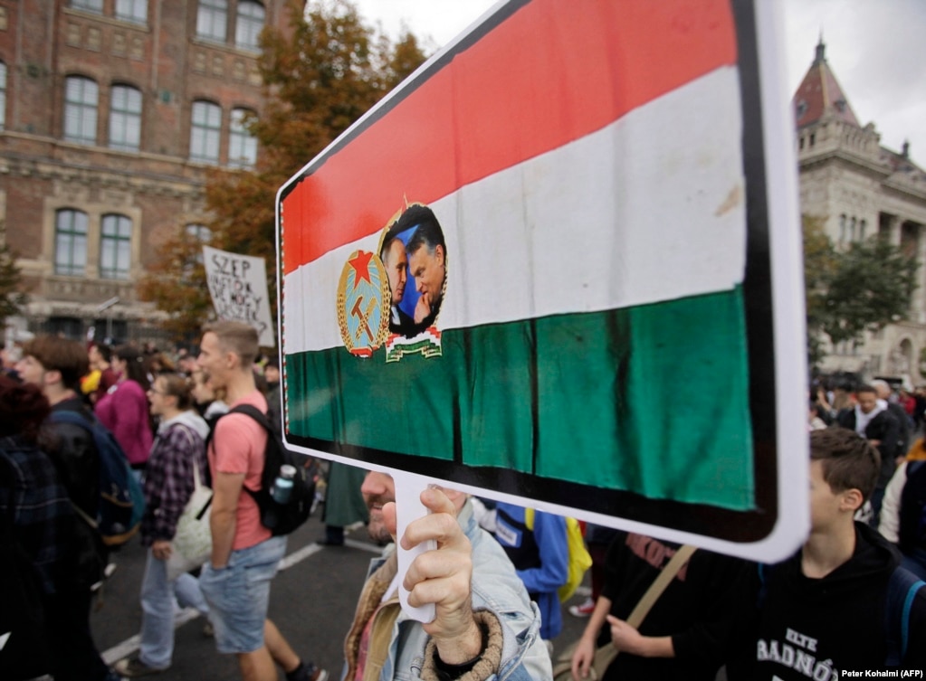 Një protestues mban në dorë një pankartë që tregon presidentin rus, Vladimir Putin, dhe kryeministrin e Hungarisë, Viktor Orban, brenda një flamuri hungarez të epokës komuniste. Hungaria është goditur rëndë nga rritja masive e inflacionit që nga fillimi i vitit 2021.