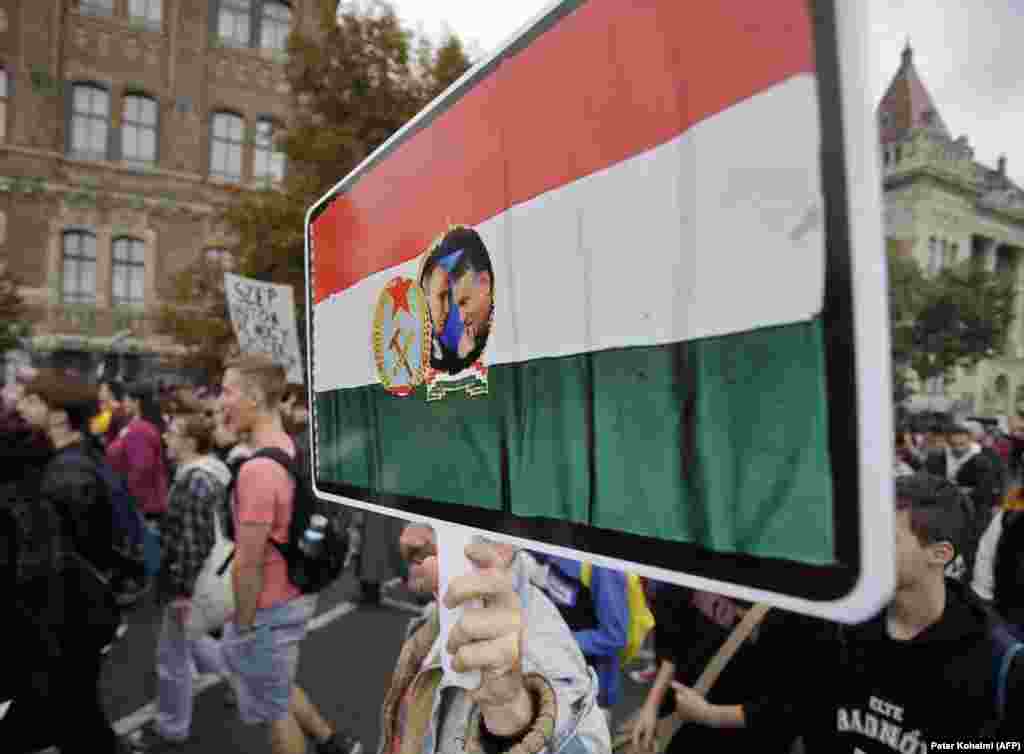 Një protestues mban në dorë një pankartë që tregon presidentin rus, Vladimir Putin, dhe kryeministrin e Hungarisë, Viktor Orban, brenda një flamuri hungarez të epokës komuniste. Hungaria është goditur rëndë nga rritja masive e inflacionit që nga fillimi i vitit 2021.