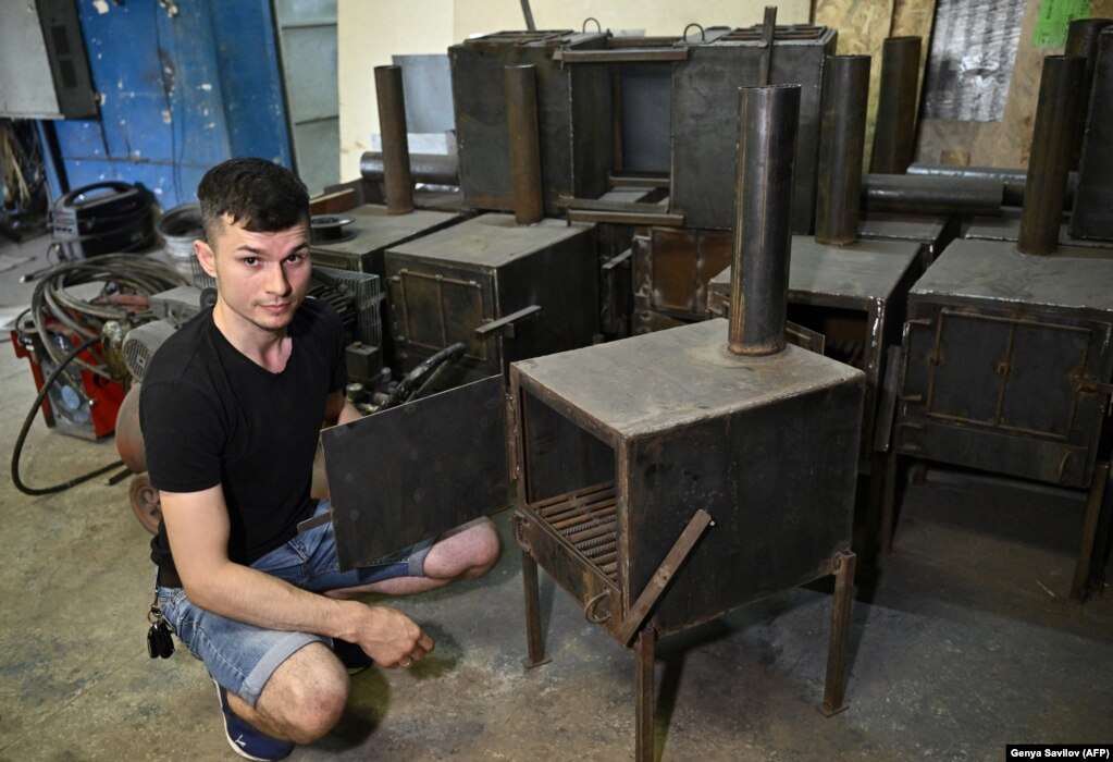 Farkëtari Anton Zaika tregon një stufë të sapobërë në punëtorinë e tij në Sumy në gusht. Stufat me dru janë projektuar nga 32-vjeçari posaçërisht për t&#39;u përdorur në llogore si burim ngrohtësie dhe si pajisje gatimi.