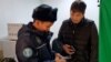 Видеооператор Азаттыка Ержан Амирханов и сотрудник полиции в столичном офисе Азаттыка. Астана, 27 октября 2022 года