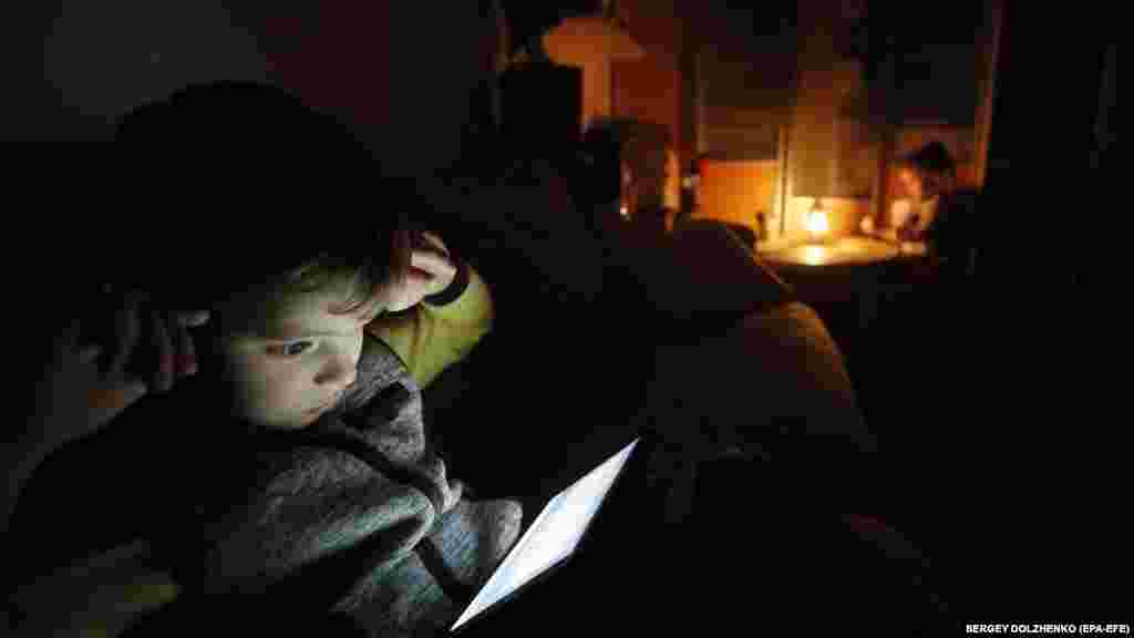 Un copil folosește tableta, Kiev, 20 octombrie 2022. Guvernul le-a ordonat ucrainenilor să reducă la minimum consumul de energie electrică între orele 7:00 și 23:00.