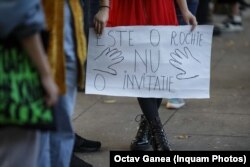 O tânără ține o pancartă cu mesajul „Este o rochie, nu o invitație”, la marșul „Împreună pentru siguranța femeilor” organizat pentru a atrage atenția asupra violenței îndreptate asupra femeilor, București, 23 octombrie 2022.