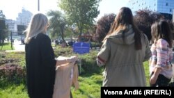 Školske drugarice Dušana Jovanovića ispred simbolične table sa imenom ubijenog romskog dečaka, u parku na beogradskom Trgu Slavija, 27. oktobar 2022. 