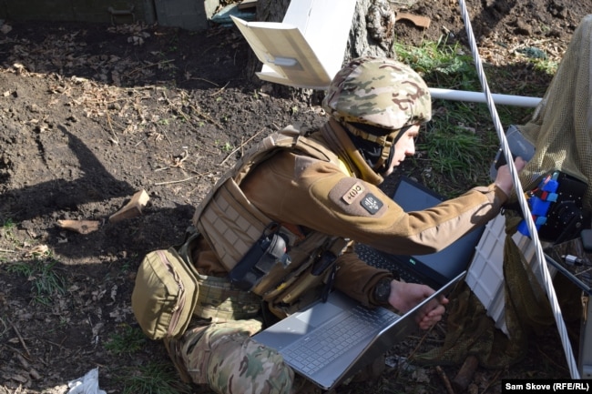 Kim works with a loaded laptop to reboot a drone.