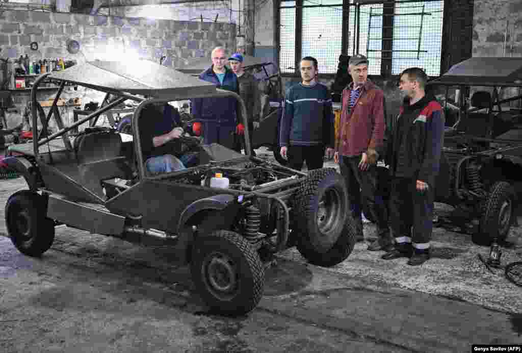Lucrători cu un vehicul de tip buggy proaspăt asamblat într-un atelier din Krivoi Rog, centrul Ucrainei, septembrie 2022.
