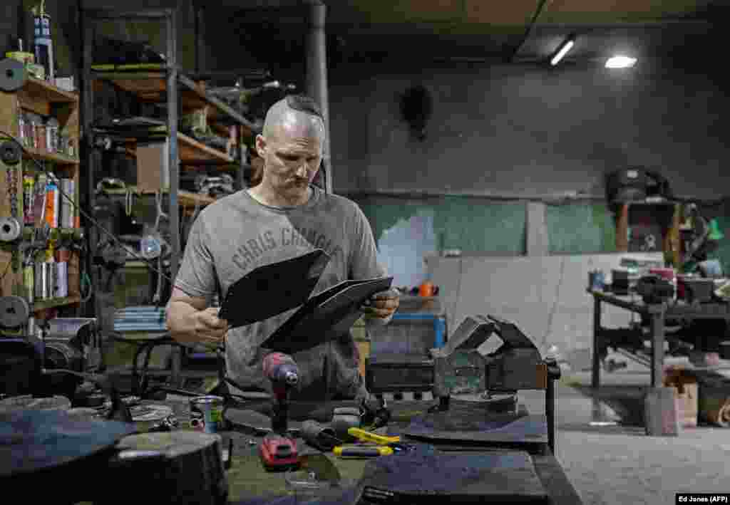 Andriy Paliy prepares materials that he uses to produce armor plates at his workshop in Zaporizhzhya in May. Before the invasion, the self-taught blacksmith made swords and medieval suits of armor but now he makes ballistic protection for the Ukrainian military. &nbsp;