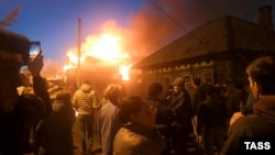 Residents of Irkutsk watch a blaze that erupted after a Russian military plane crashed into a residential building on October 23. 