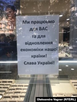 Un semn în vitrina unui magazin din Ujhorod: „Lucrăm pentru voi și pentru redresarea economiei țării.”