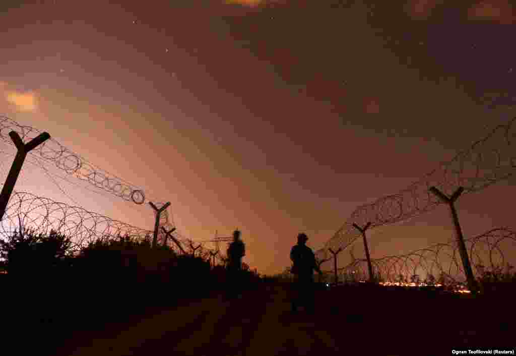 Macedonian soldiers patrol inside razor-wire fences on the border between Macedonia and Greece in July 2019. &nbsp;