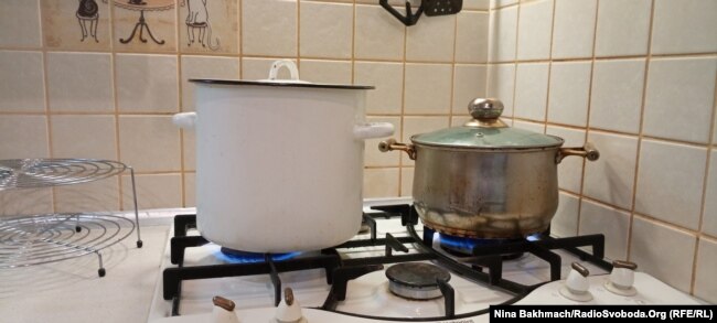 Valentyna duke ngrohur dy tenxhere me ujë pasi avulli që prodhojnë e ndihmon të ngroh pak kuzhinën e saj.