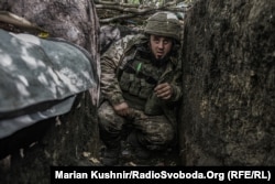 Військовий ЗСУ ховається в окопі під час атаки російських танків