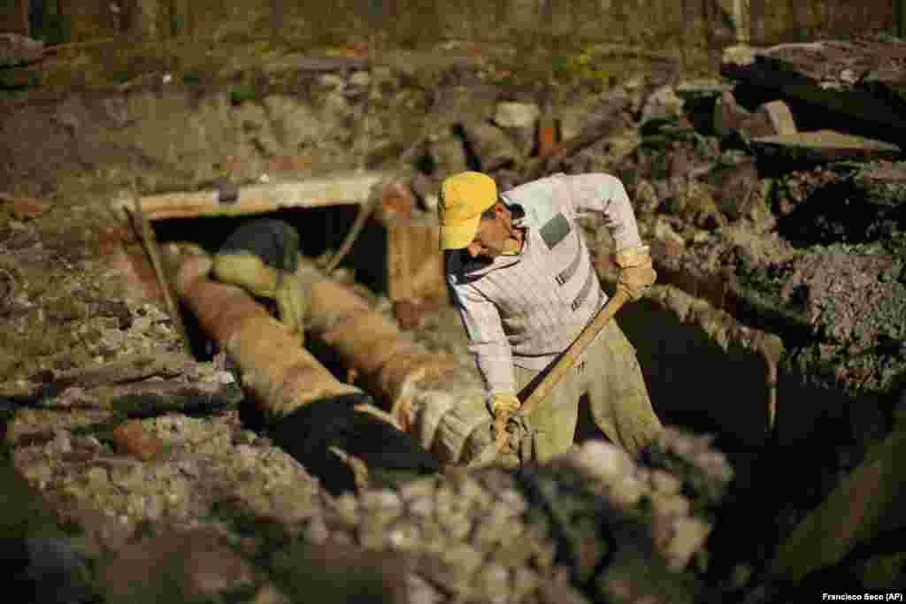 Workers repair a central heating pipe in the Saltivka neighborhood of Kharkiv on October 15.&nbsp; Authorities are working to gradually restore electricity to the area in the coming days, and repairs to water and gas infrastructure will come next, according to Roman Semenukha, a deputy with the Kharkiv regional government. &quot;Only after that will we be able to begin to restore heating,&quot; he said. &nbsp;