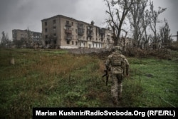 Військовий ЗСУ йде до розбитих будівель у місті Соледарі