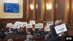 Депутати от БСП държат листи с надпис "Не на оръжията! МИР" след края на гласуването.