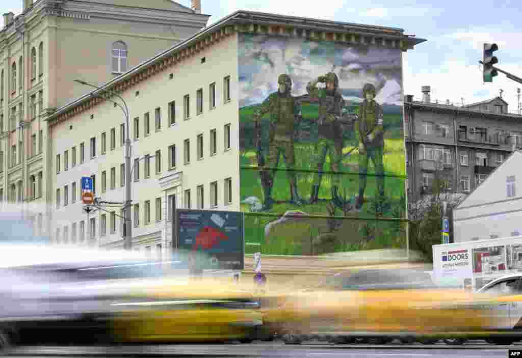 Cars in Moscow in September pass under a mural of Russian soldiers bearing the &lsquo;Z&rsquo; symbol used as a pro-war emblem. The image references a famous tsarist-era painting of three Russian knights. &nbsp;