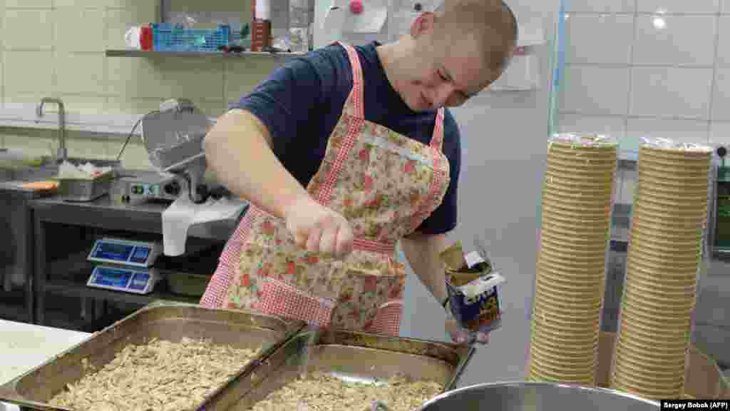 Волонтер готовит еду для солдат и участников территориальной обороны, защищающих восточный город Харьков. Март 2022 года