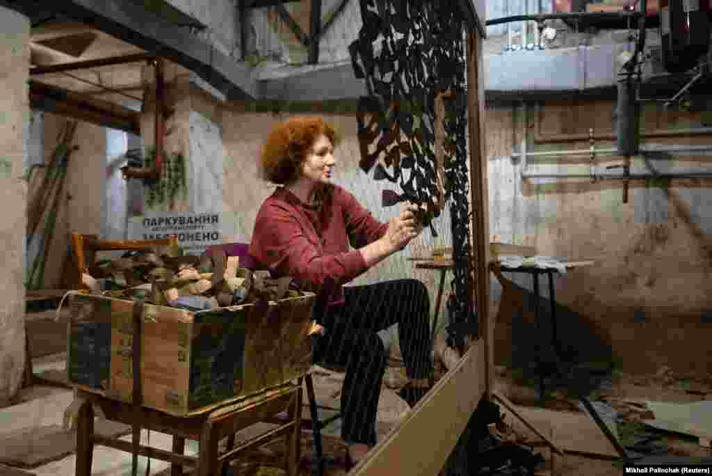 A volunteer weaves camouflage netting inside a bomb shelter in Kyiv in April. &nbsp;The netting is used by both sides to hide vehicles and troops from drone cameras.