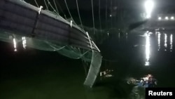  Вид на поврежденную часть подвесного моста после его обрушения в городе Морби в западном штате Гуджарат, Индия, 30 октября 2022 года. 