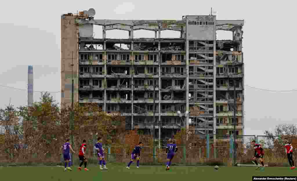 Під час футбольної гри місцевих жителів на тлі знищеної будівлі в Маріуполі, 28 жовтня 2022 року