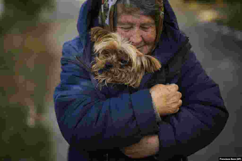 Женщина прижимает к себе собаку в Кившаровке, 16 октября. Температура воздуха на востоке Украины опускается ниже нуля. Люди, которые остались на местах и не бежали от ожесточенных боев, непрекращающихся обстрелов и российской оккупации, теперь должны готовиться к зиме