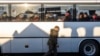 A Polish soldier passes by as people sit in a bus after they crossed the Polish-Ukrainian border on March 18, 2022. More than 3 million Ukrainians fled across the border, mostly women and children, after Russia's invasion, according to the UN.