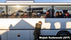 A Polish soldier passes a bus after it crossed the Polish-Ukrainian border at Medyka in March.